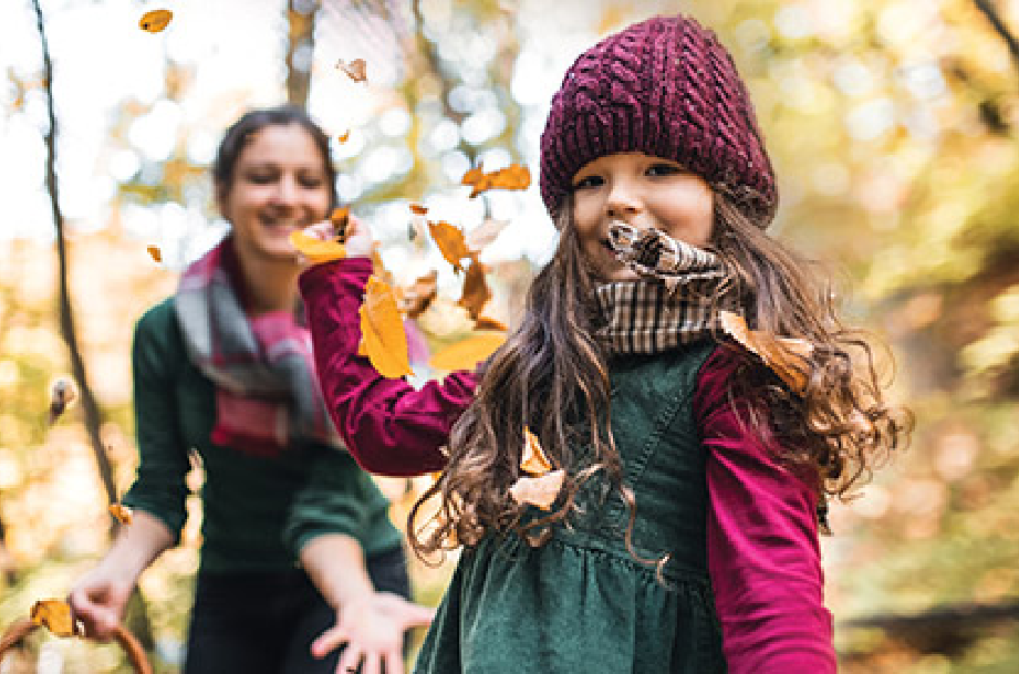 Child catching autumn leaves outdoors